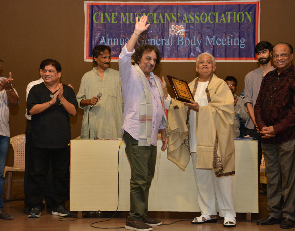 Shri Pyarelal Sharma felicitating the celebrated rhythm arranger-composer Shri Babla